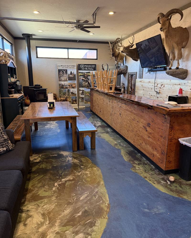 Great room at The Cockhouse with a bighorn ram mount and long bar