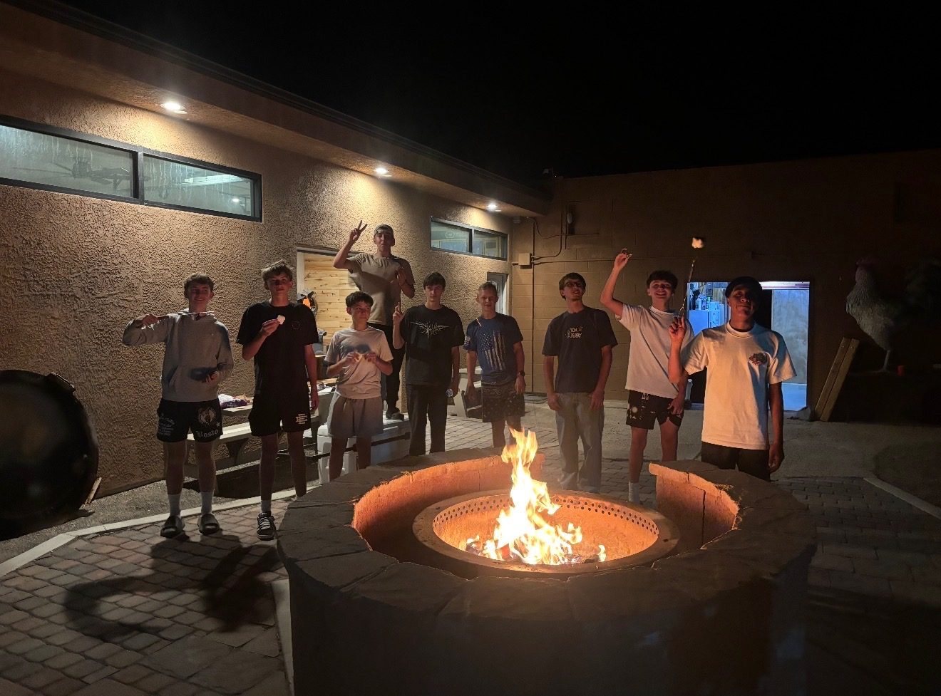 Guests gathered around the fire pit at The Cockhouse at night